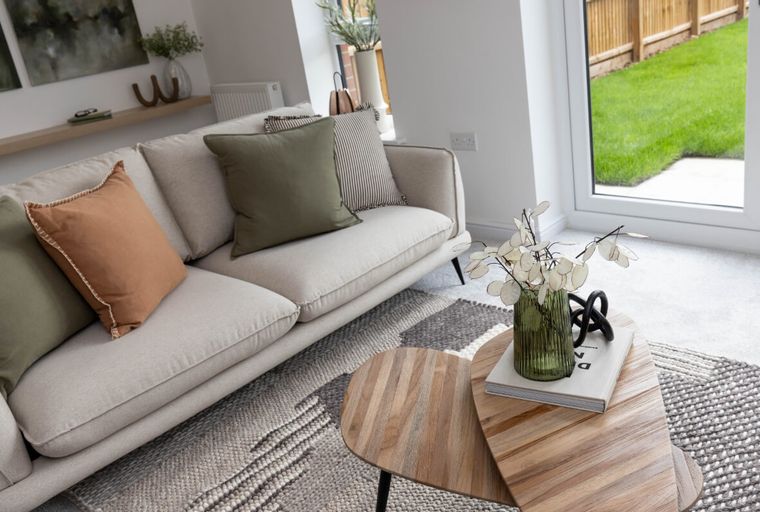 A living room with a sofa, coffee table, and rug.