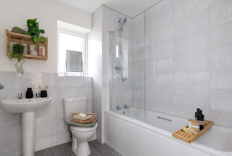 A bathroom with a sink, toilet, and bathtub with a shower.