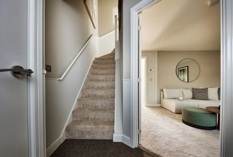 A view of a staircase and a living room through an open doorway.
