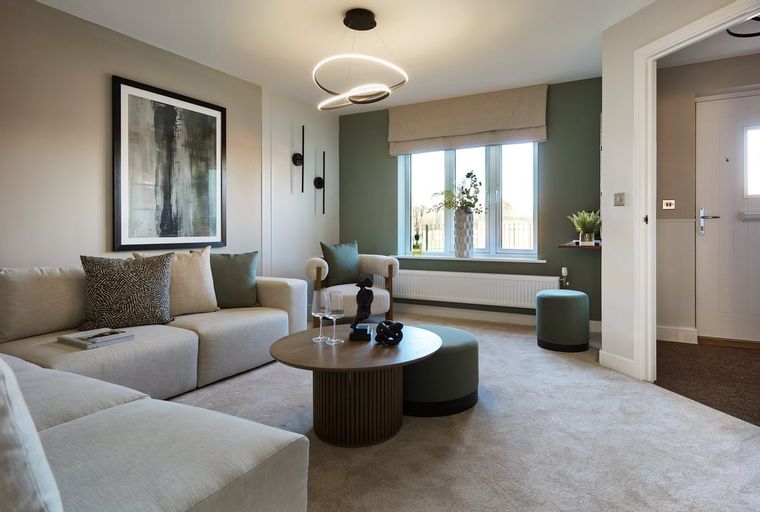 A living room with a sectional sofa, coffee table, armchair, and a large window.