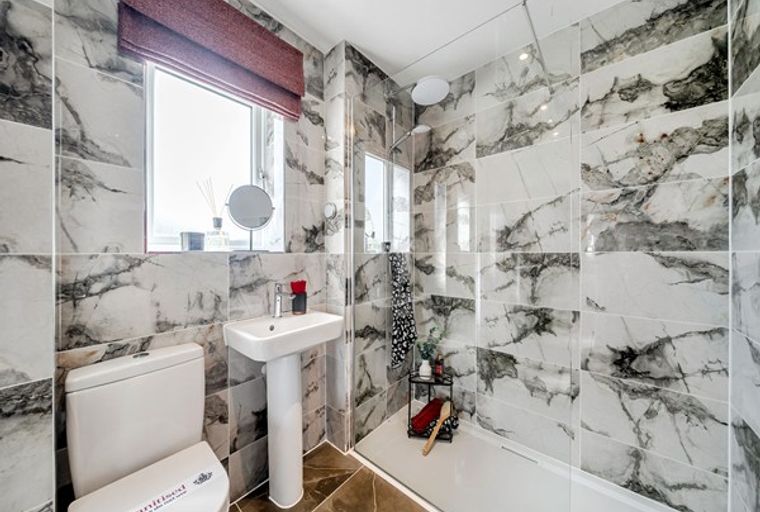 A bathroom with a toilet, sink, and a walk-in shower.