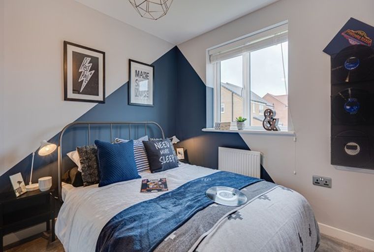 A bedroom with a bed, pillows, and a bedside table.