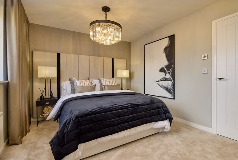 A bedroom with a bed, headboard, bedside tables, lamps, and a large artwork.
