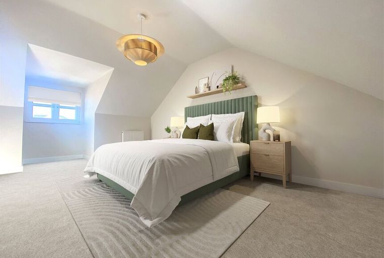 A bedroom with a bed, nightstand, and a window.