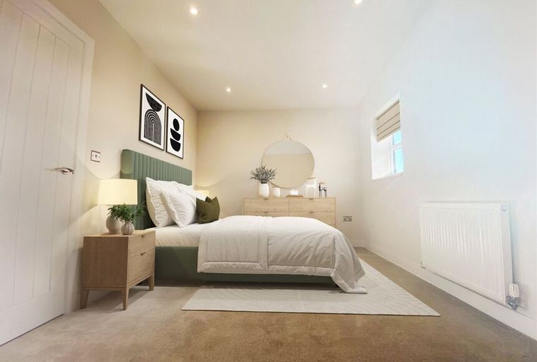 A bedroom with a bed, nightstand, dresser, and a window.