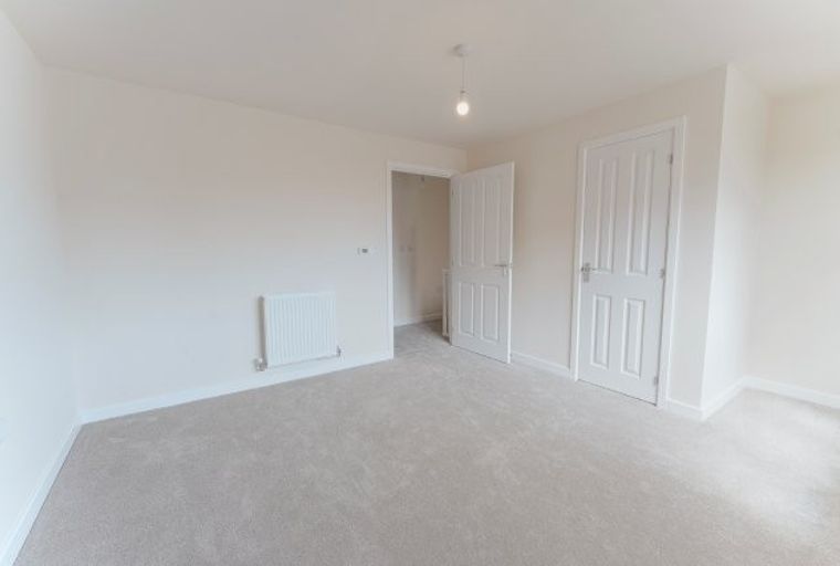 A room with two white doors and a white radiator.