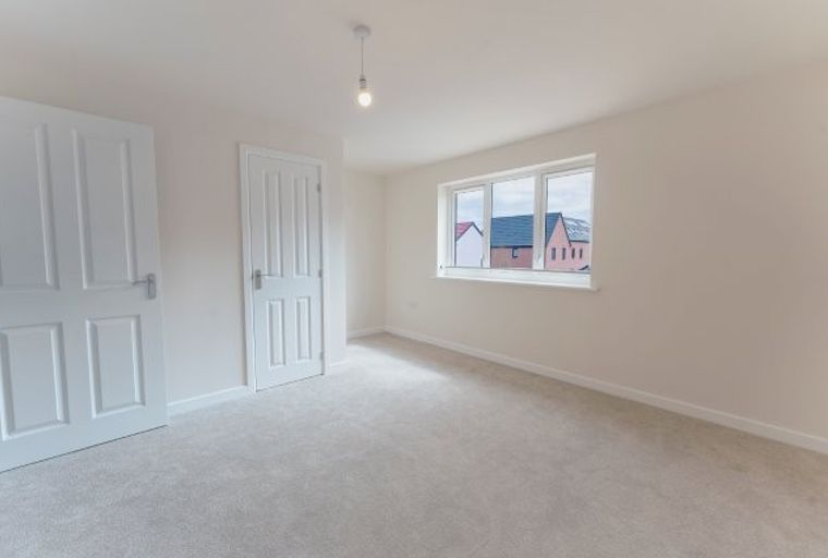 A bedroom with two doors and a window.
