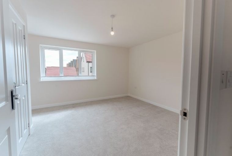 A bedroom with a window and a door.
