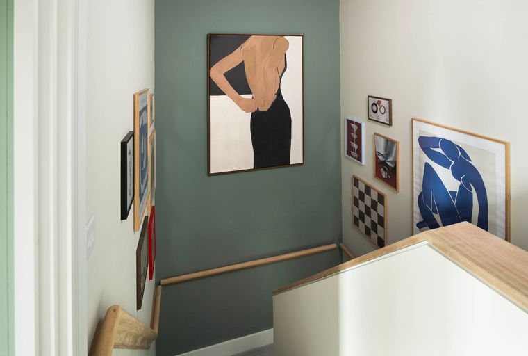 A staircase landing with a gallery wall featuring several framed artworks.