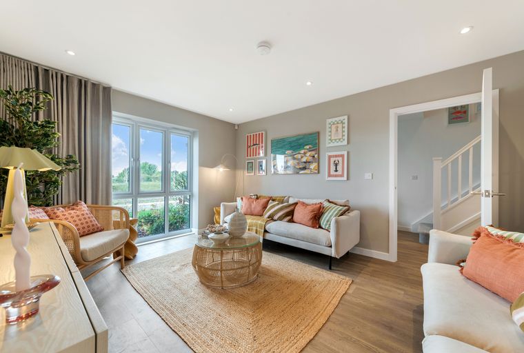 A living room with a sofa, coffee table, rug, and large windows.