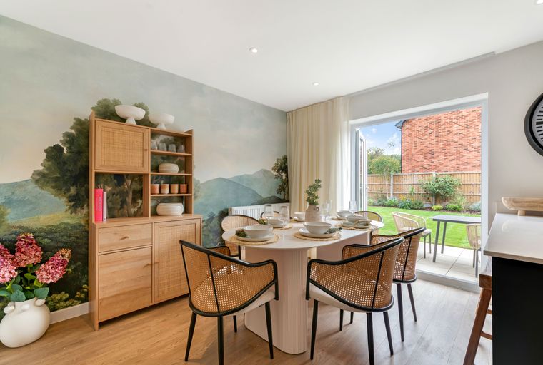 A dining room with a table, chairs, and a muraled wall.