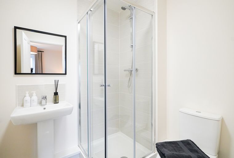 A bathroom with a sink, shower, and toilet.