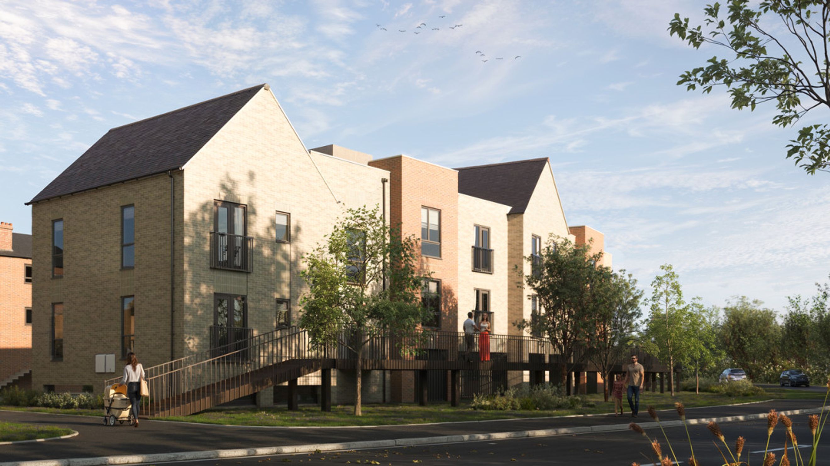 A row of modern brick townhouses with pitched roofs and balconies, connected by elevated walkways.