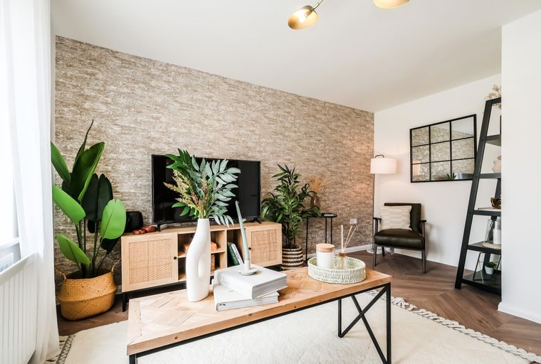A living room with a television, coffee table, and armchair.