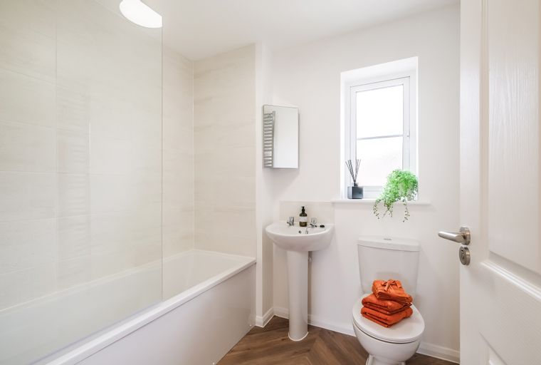 A bathroom with a bathtub, sink, and toilet.