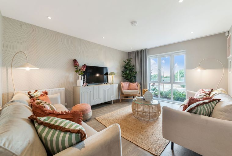 A living room with a television, sofas, a coffee table, and a large window.