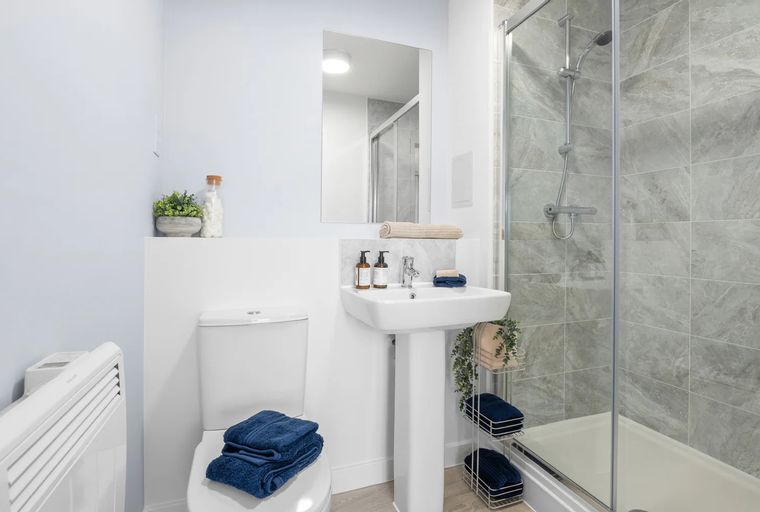 A bathroom with a toilet, sink, and shower.