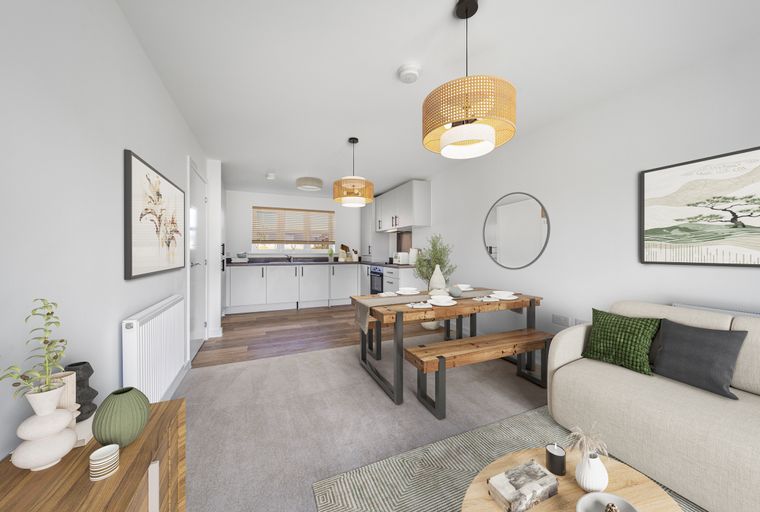 A living and dining area with a kitchen in the background.