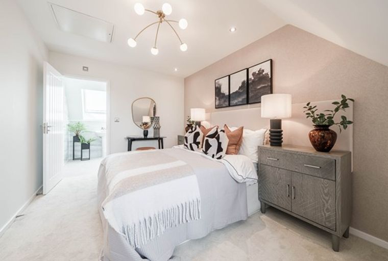A bedroom with a bed, dresser, and a chandelier.