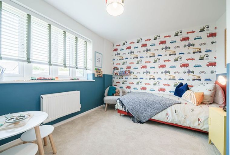 A child's bedroom with a bed, wallpaper, and a window.