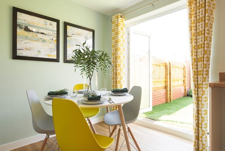 A dining room with a table, chairs, and artwork.