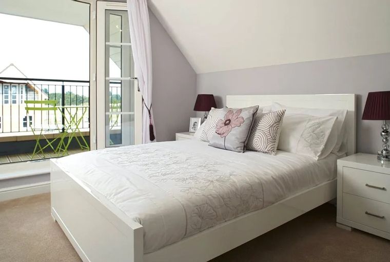 A bedroom with a bed, nightstands, and a balcony door.