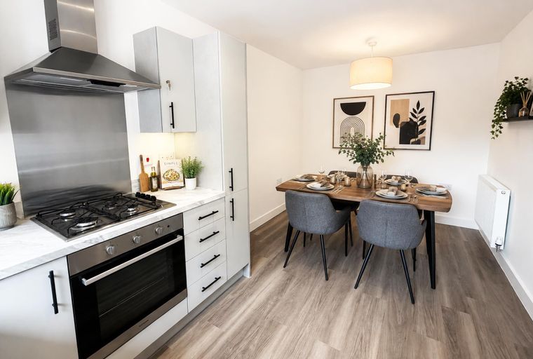 A kitchen and dining area with a gas stove, oven, dining table, and chairs.