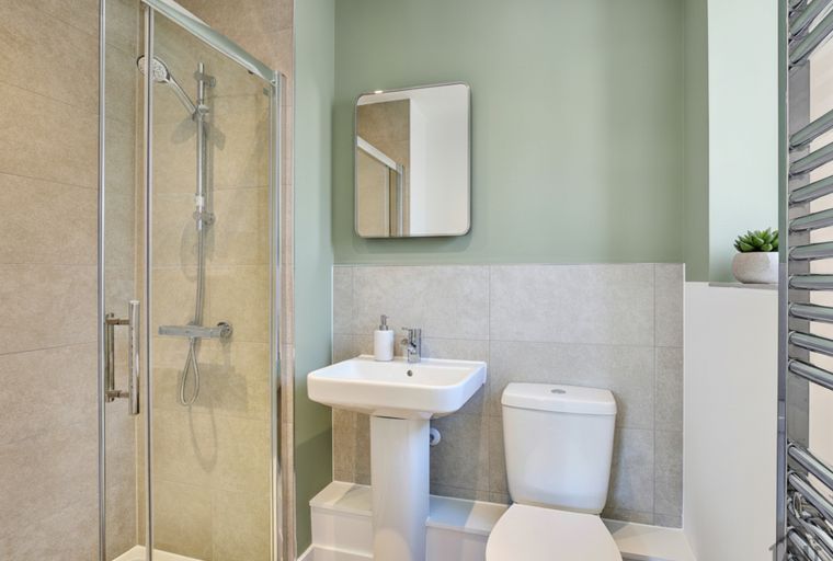 A bathroom with a shower, sink, and toilet.