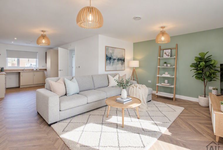 A living room with a sectional sofa, coffee table, rug, and pendant lights.