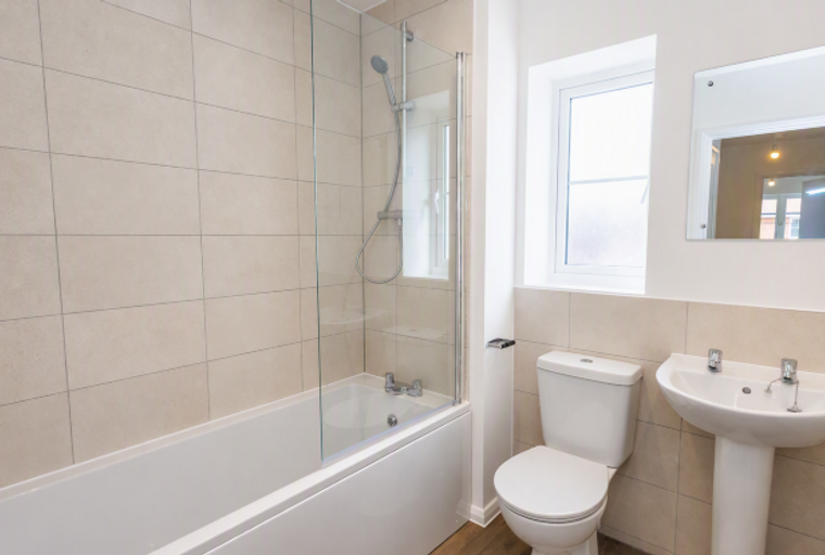 A bathroom with a bathtub, shower, toilet, and sink.