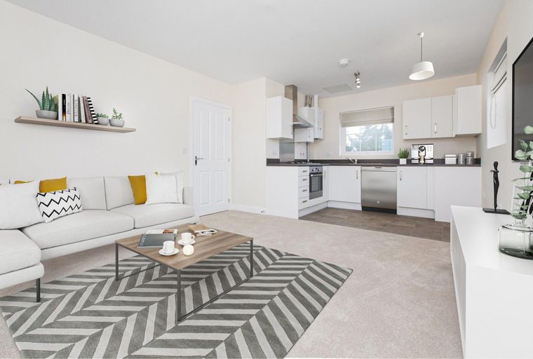 A living room and kitchen area with a sofa, coffee table, and kitchen cabinets.