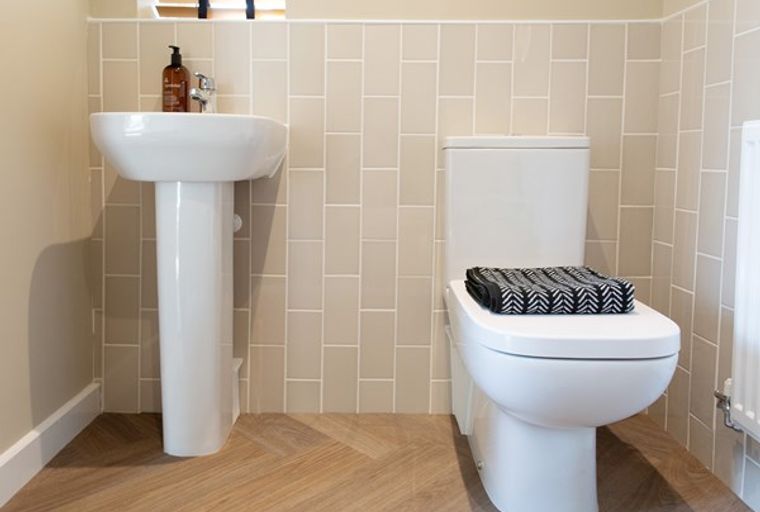A bathroom with a sink, a toilet, and tiled walls.