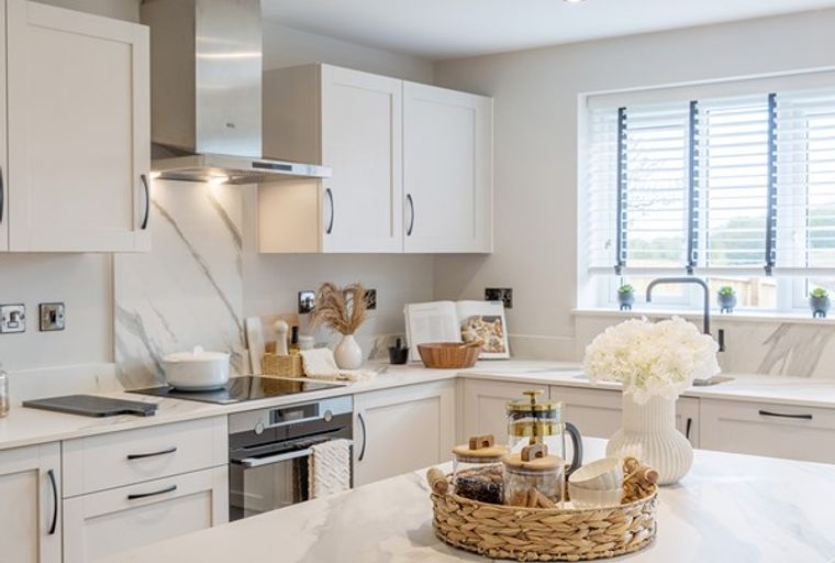 A modern kitchen with white cabinets, a marble backsplash, and a kitchen island.