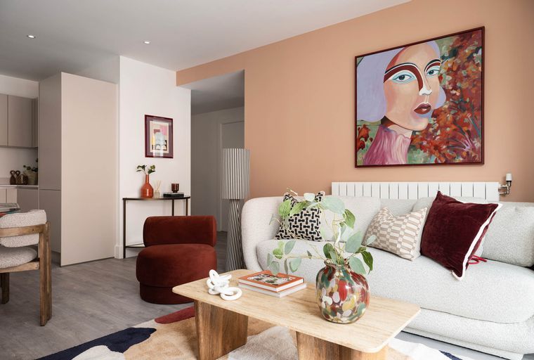 A living room with a sofa, coffee table, and abstract art on the wall.