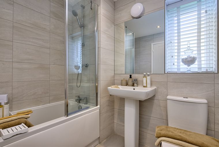A bathroom with a bathtub, shower, sink, and toilet.