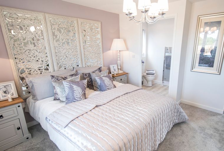 A bedroom with a bed, bedside tables, and an adjoining bathroom.