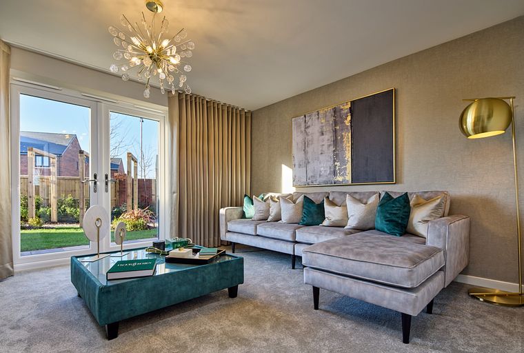 A living room with a sectional sofa, coffee table, and a chandelier.
