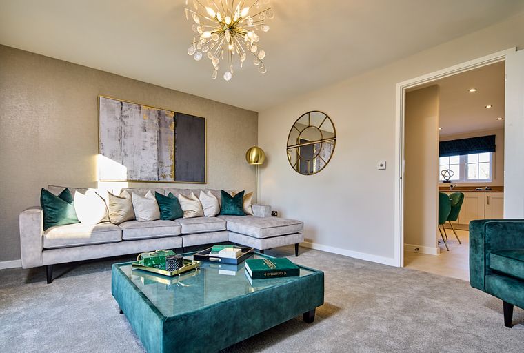 A living room with a sectional sofa, coffee table, and abstract art.