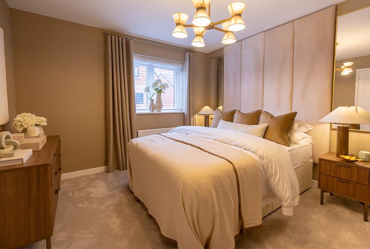 A bedroom with a bed, dresser, and window.