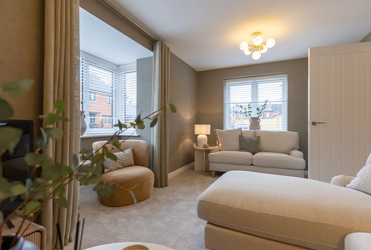 A living room with a sofa, chaise lounge, and armchair.