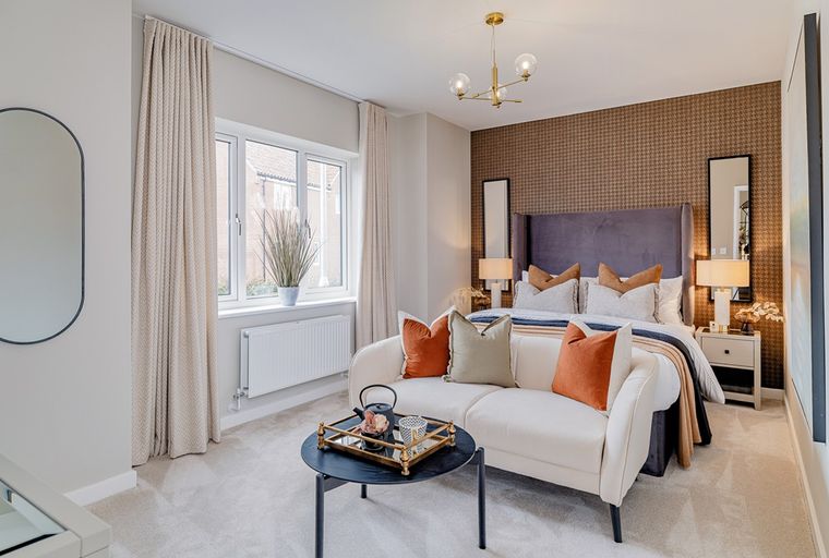 A bedroom with a bed, sofa, and coffee table.