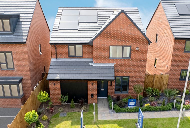 A modern red brick house with a garage, solar panels, and a landscaped front yard.