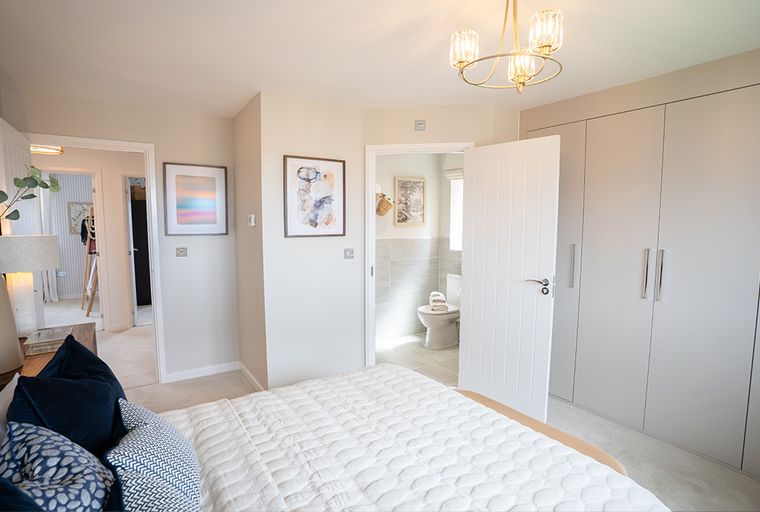 A bedroom with a bed, a wardrobe, and an en-suite bathroom.