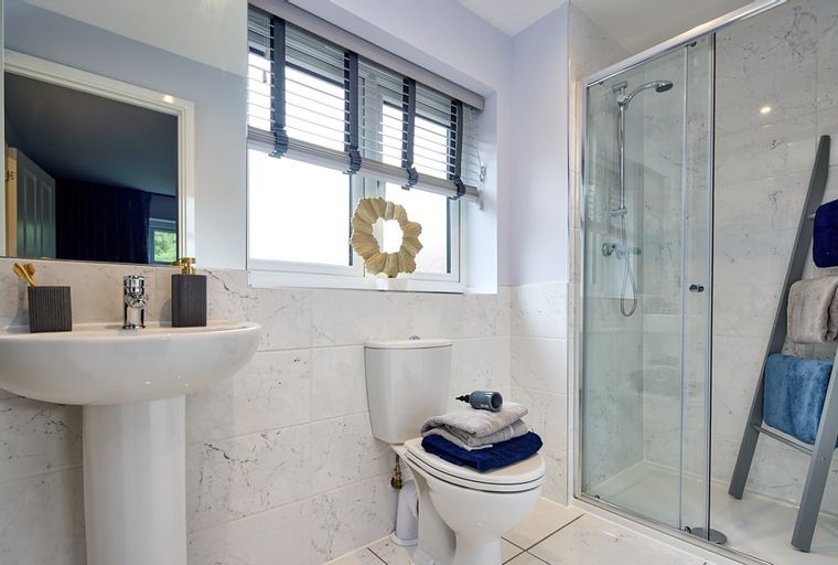 A bathroom with a sink, toilet, and shower.