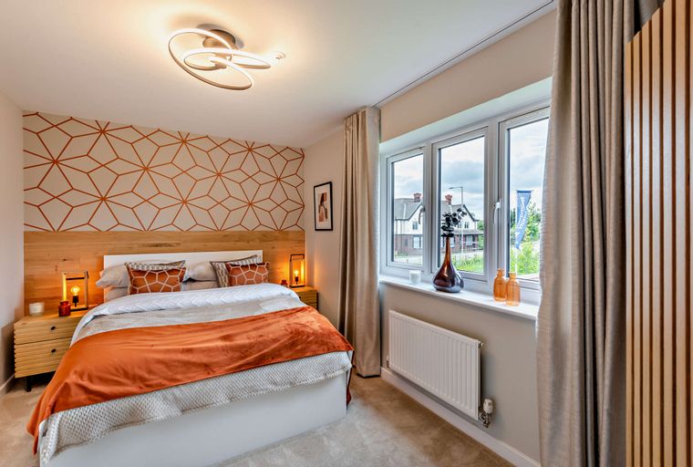 A bedroom with a bed, bedside tables, a window, and a ceiling light.