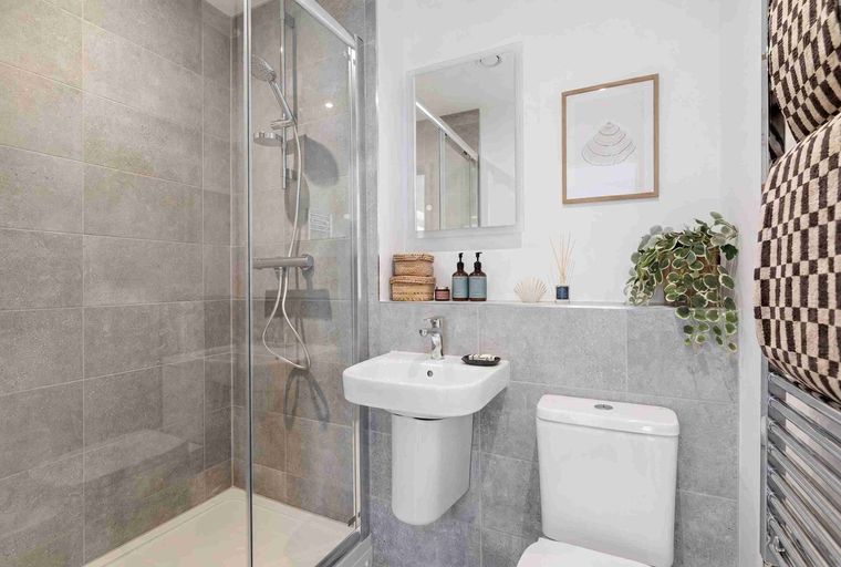A bathroom with a shower, sink, and toilet.