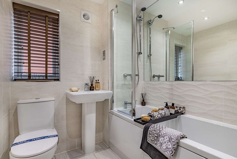 A bathroom with a toilet, sink, and bathtub with a shower.