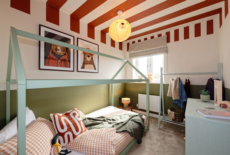 A child's bedroom with a house bed, gingham bedding, and bear-themed decor.