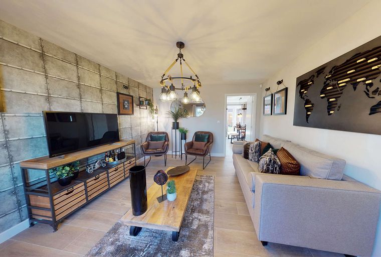 A living room with a sofa, armchairs, a coffee table, and a television.
