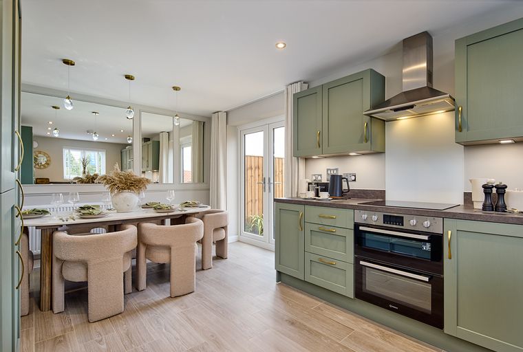 A kitchen and dining area with sage green cabinets, a marble dining table, and boucle chairs.
